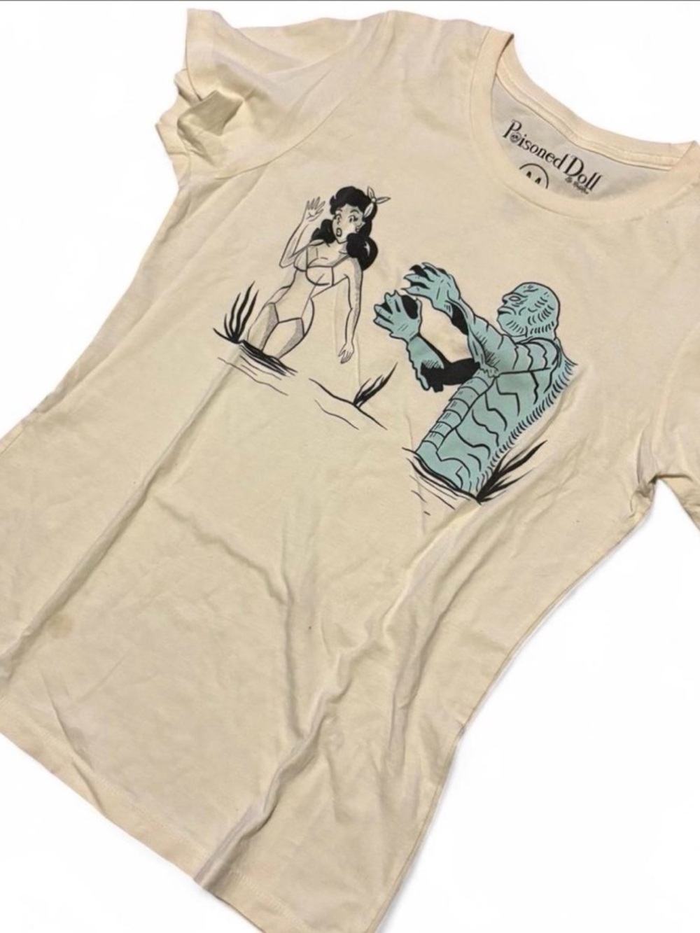 Poisoned Doll Graphic Tee in Beige with Teal Monster